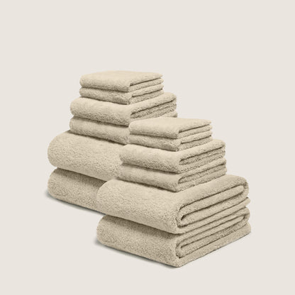 Cream cotton towel set with plush looped texture, stacked in multiple folds