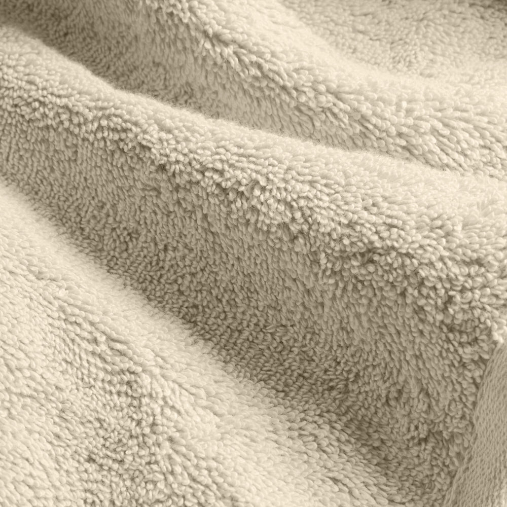 Cream cotton towel fabric close-up with dense plush looped pile