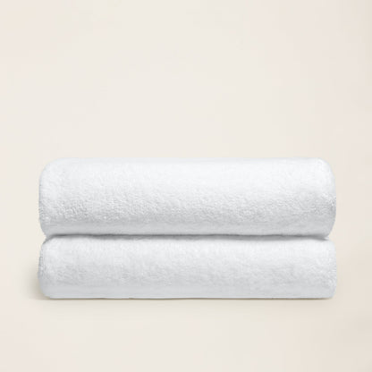 White cotton bath towel with plush looped texture, folded in half