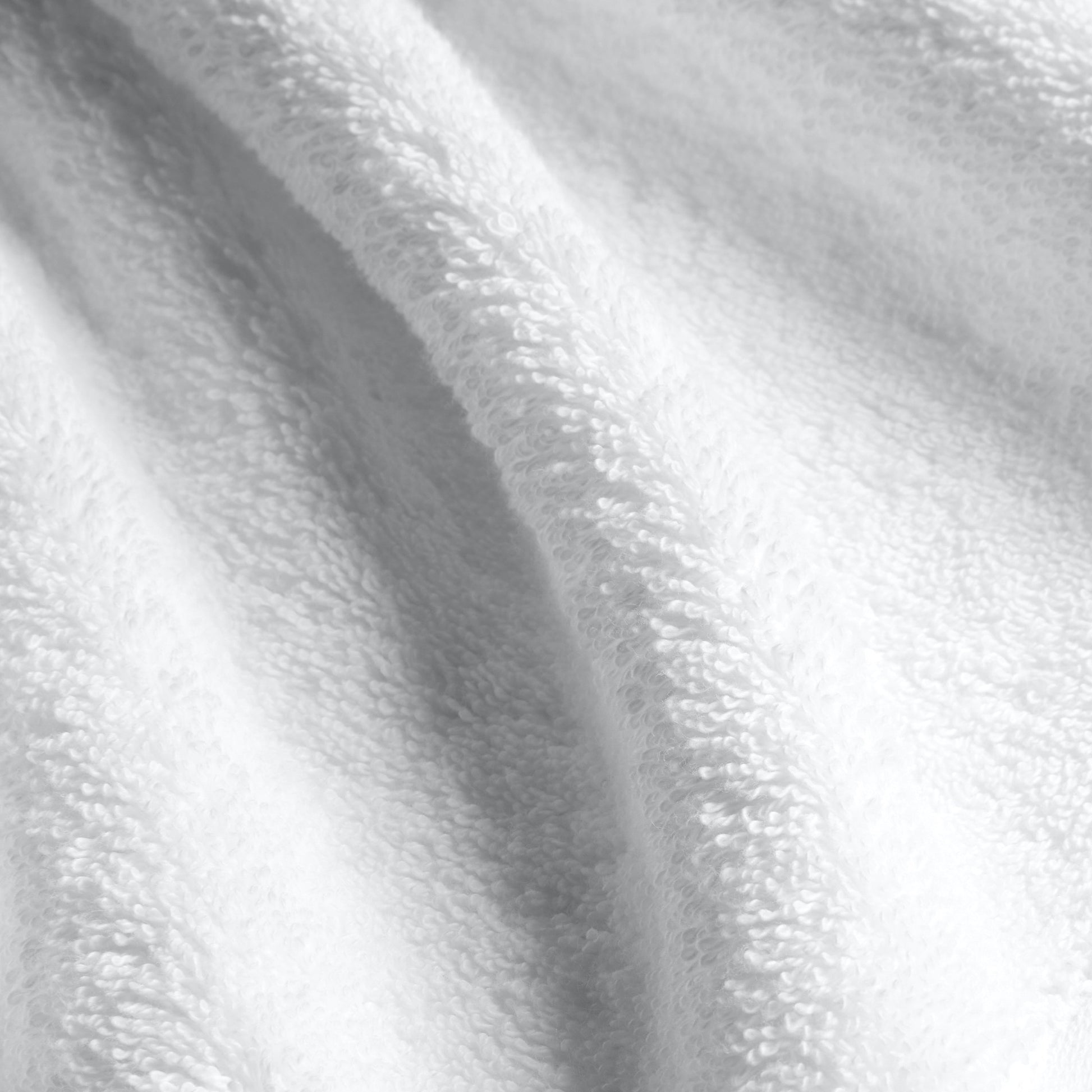 White cotton towel fabric close-up with dense plush looped pile