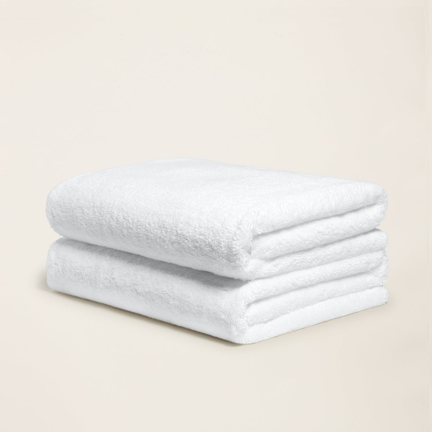 White cotton towel with plush looped texture, folded into a neat roll