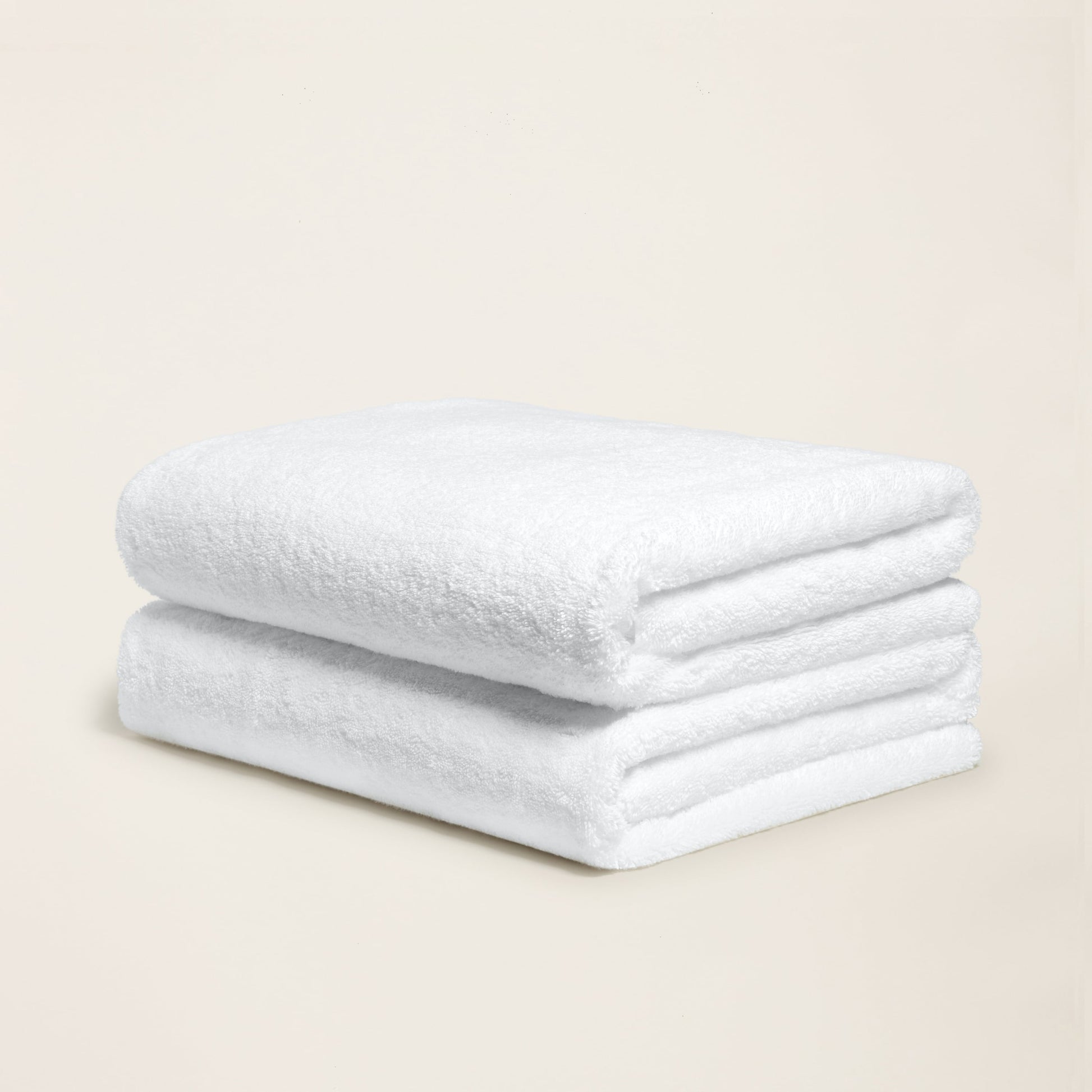 White cotton towel with plush looped texture, folded into a neat roll