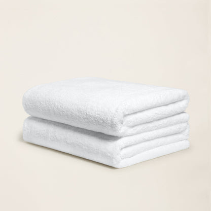 White cotton towel with plush looped texture, folded into a neat roll