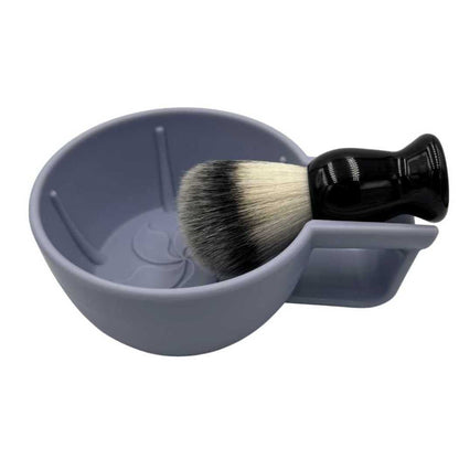 Gray shaving bowl with handle and embossed flower pattern, holding a shaving brush