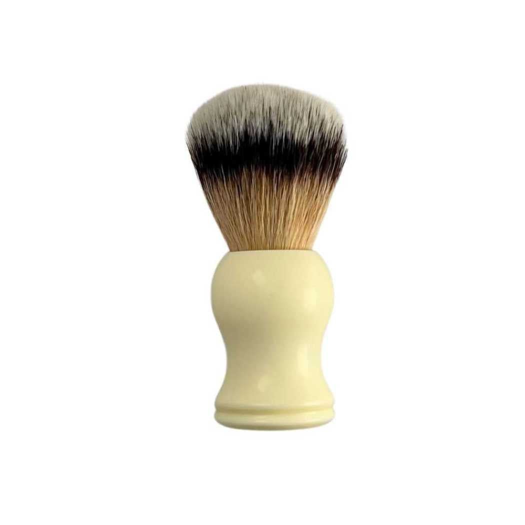 Shaving brush with cream handle and dark-to-light bristles, round top