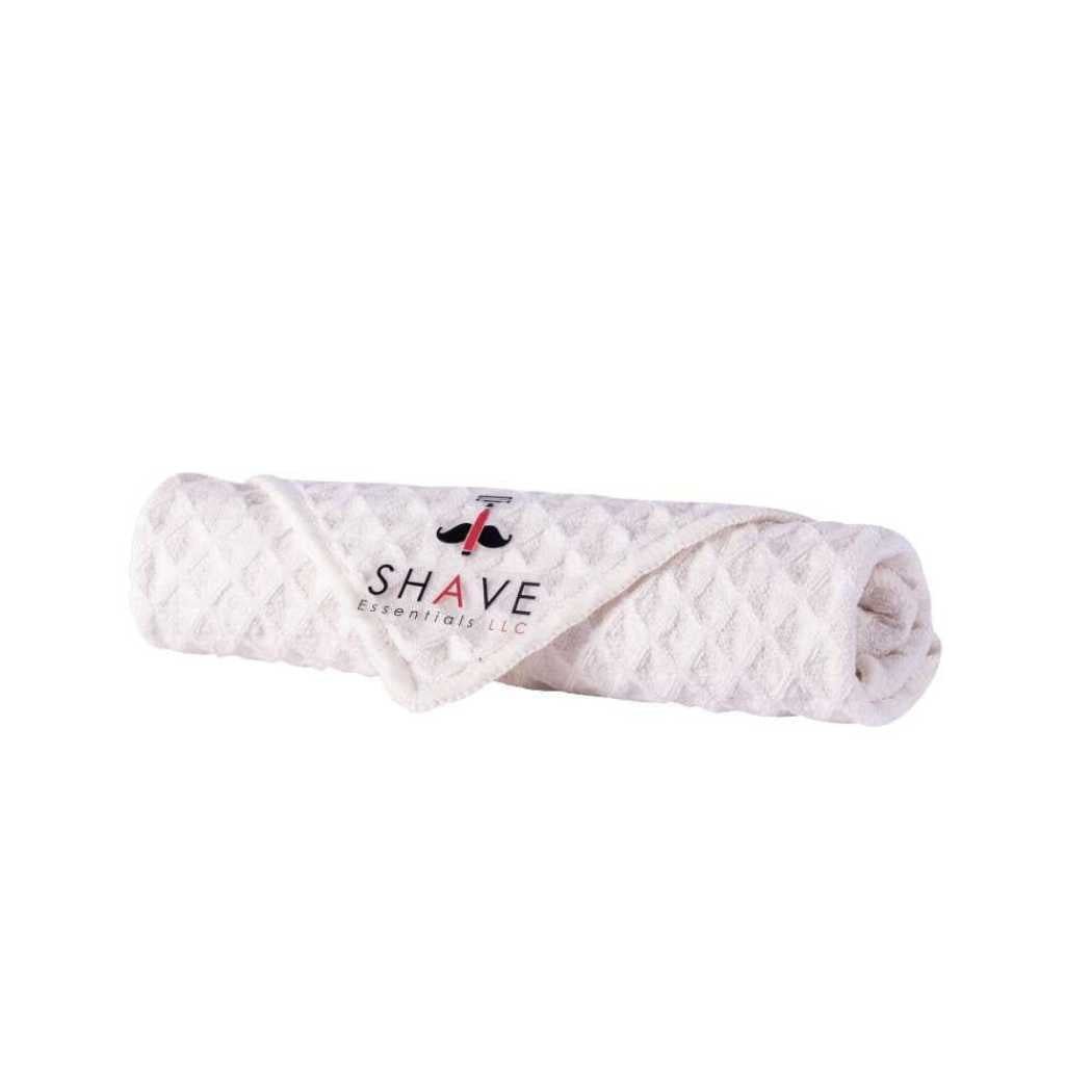 Rolled light pink waffle-knit shave towel with SHAVE logo