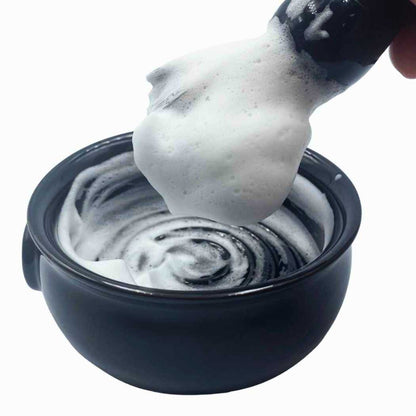 Shaving soap lather in dark bowl, soap scoop with foam