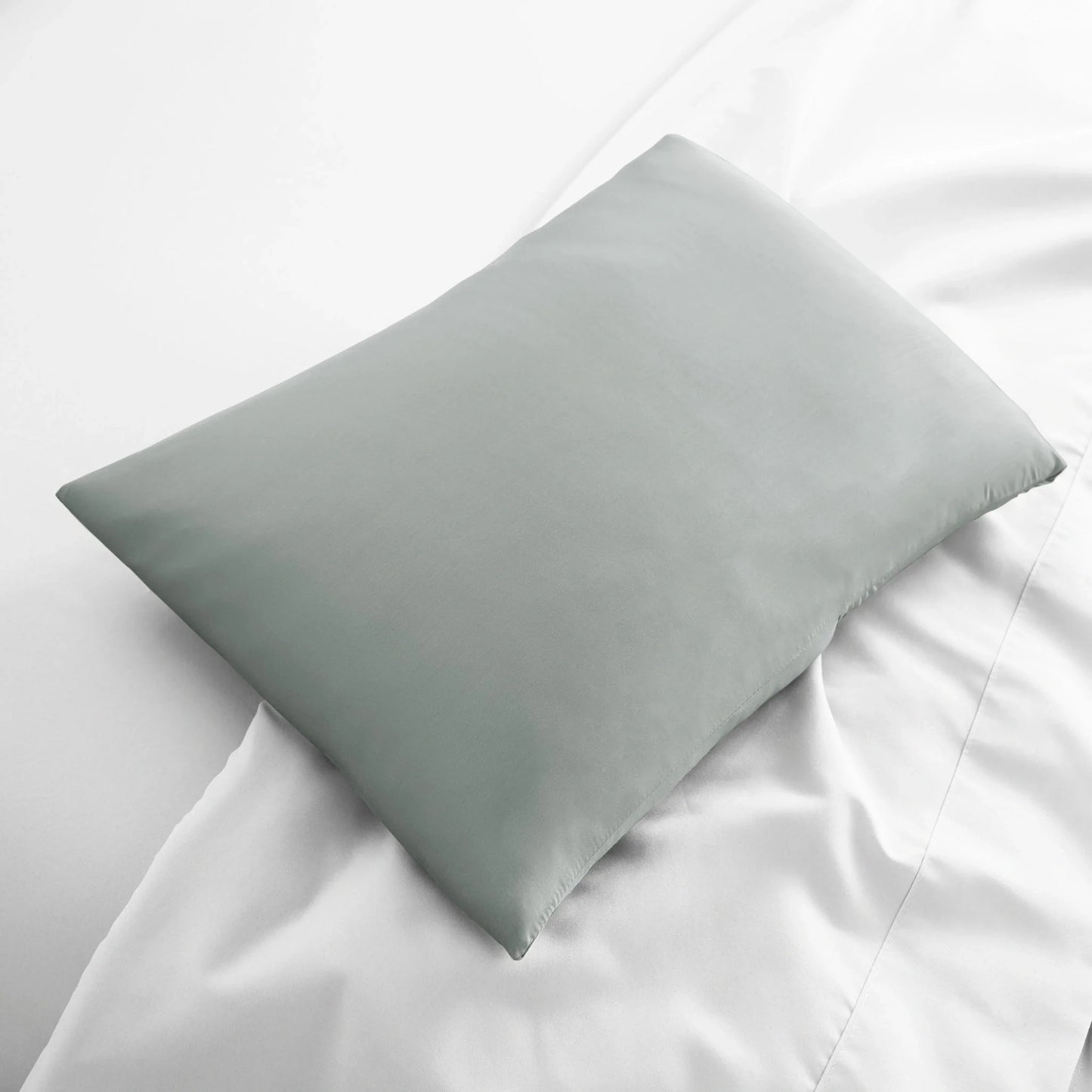 Light gray travel pillowcase, folded square view with smooth fabric.