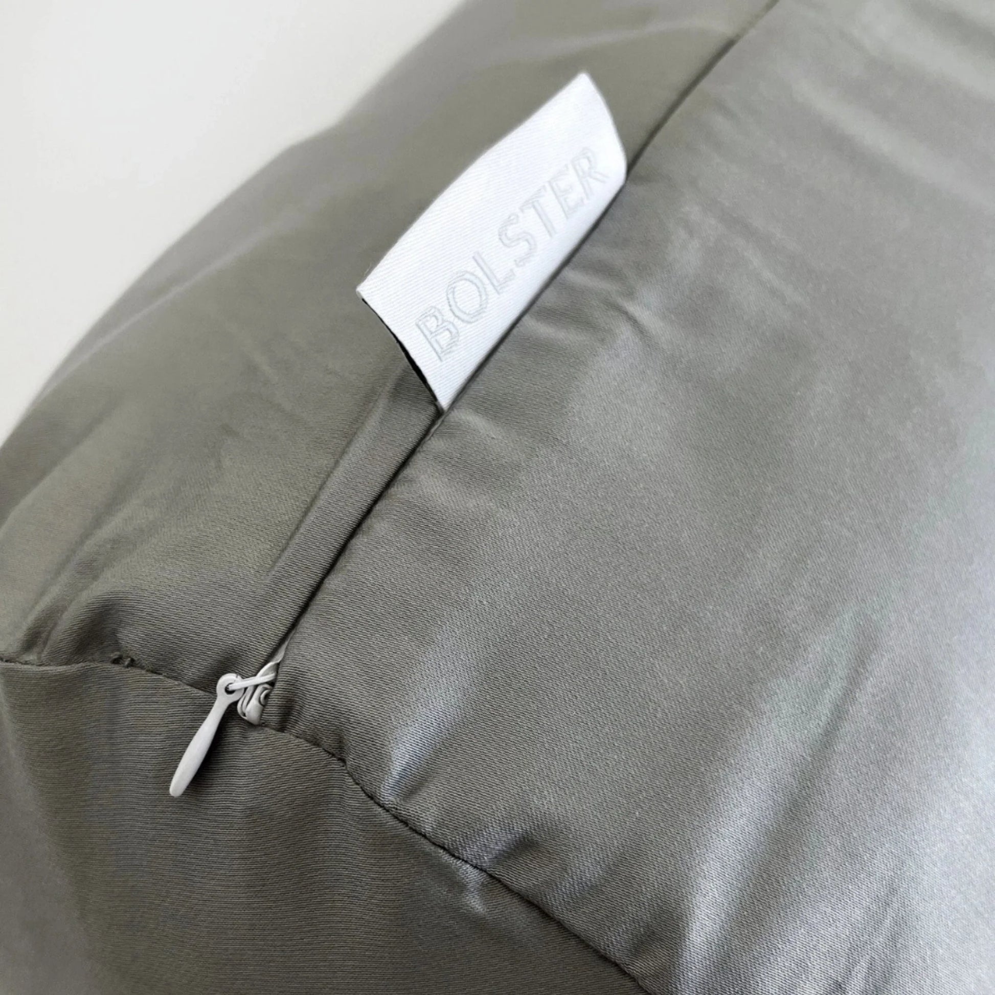 Light gray bolster pillowcase close-up, BOLSTER label and zipper detail.