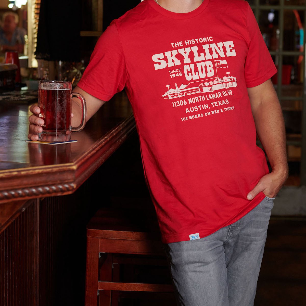 Red Skyline Club T-shirt with front graphic worn by a person