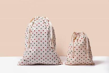 Two white cloth drawstring gift bags with red polka dots, gathered tops