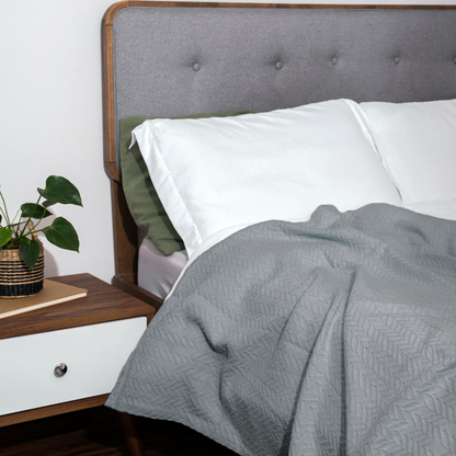 Herringbone cotton blanket, light gray, draped over bedding with chevron knit texture