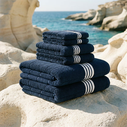Navy cotton towels with white striped borders, neatly stacked.