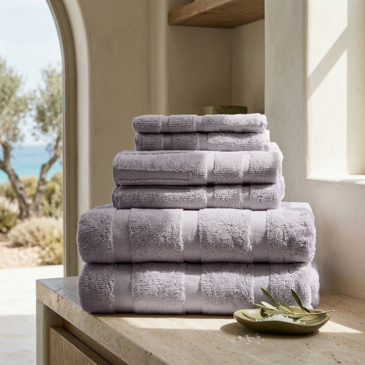 Lilac cotton towel stack with five neatly folded layers, stacked on a stand.