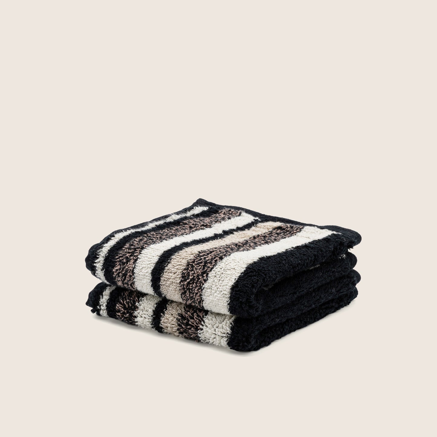 Black and cream striped cotton towel set, folded into a neat stack