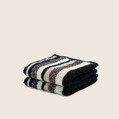 Black and cream striped cotton towel set, folded into a neat stack