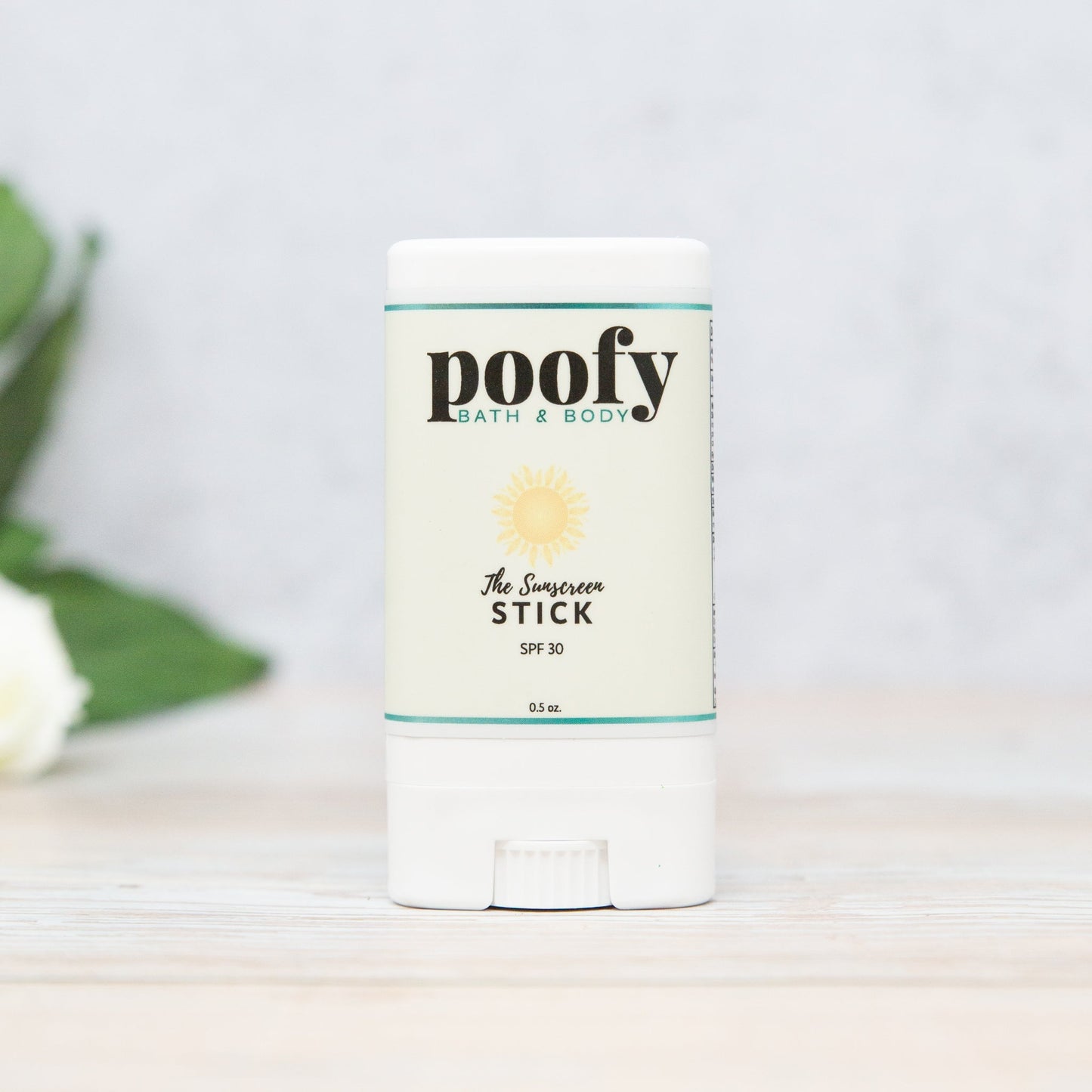 White sunscreen stick container with SPF 30 label and poofy logo