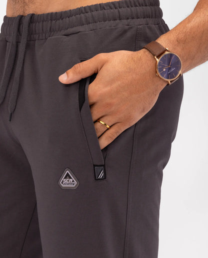 Athletic sweatpants with drawstring and front logo patches; dark grey.