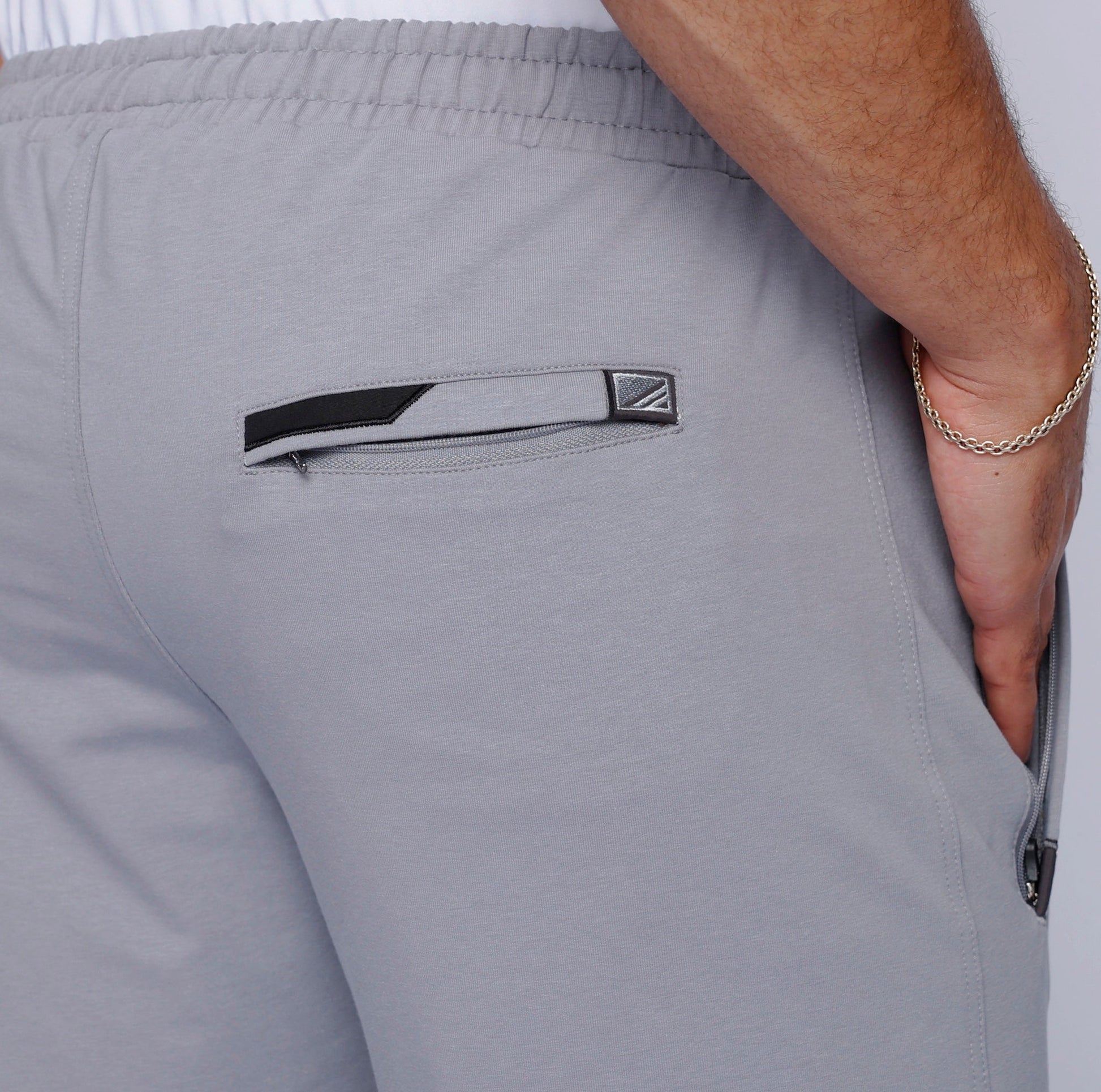 Men’s light gray heather sweatpants close-up, elastic waistband and side pocket detail
