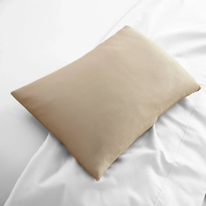 Light beige travel pillowcase, smooth fabric folded on bed