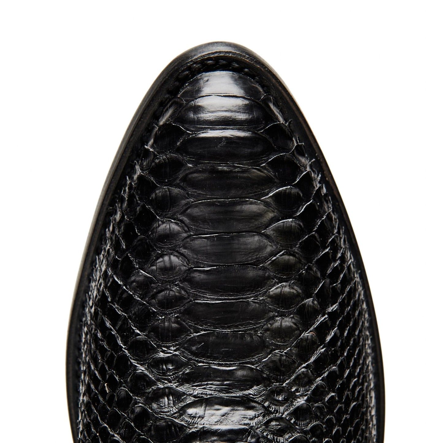 Black cowboy boot vamp close-up with crocodile-textured leather