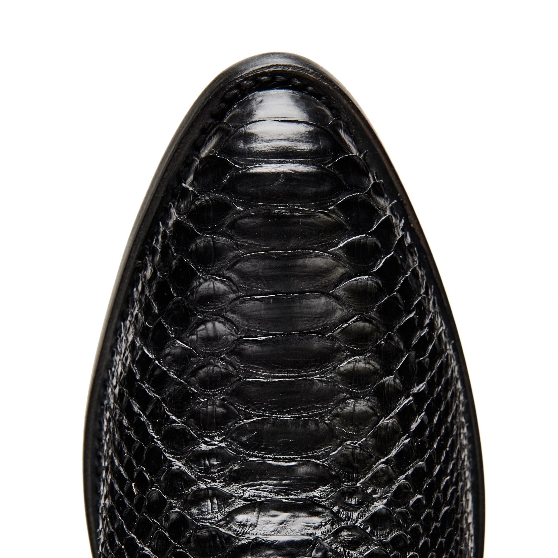 Black cowboy boot vamp close-up with crocodile-textured leather