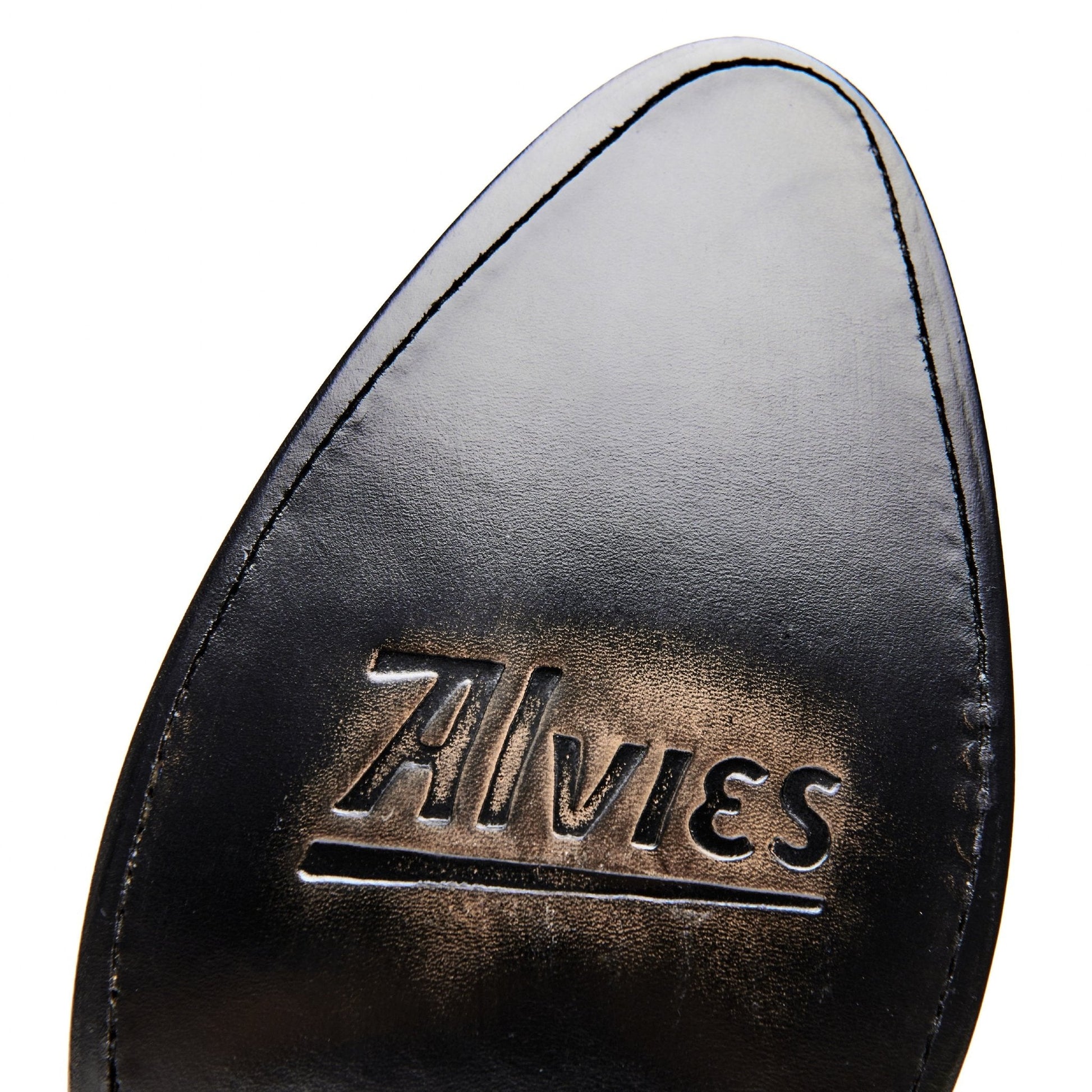 Black cowboy boot heel tab with metallic-style embossed brand lettering