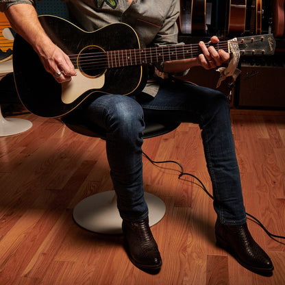 Brown leather cowboy boots worn with jeans, pointed toes and stacked leather heels