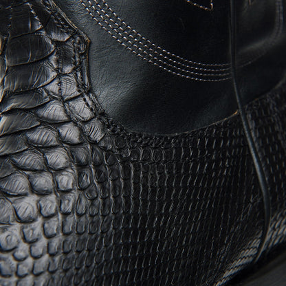 Black cowboy boot side view with crocodile-style texture and curved seam stitching