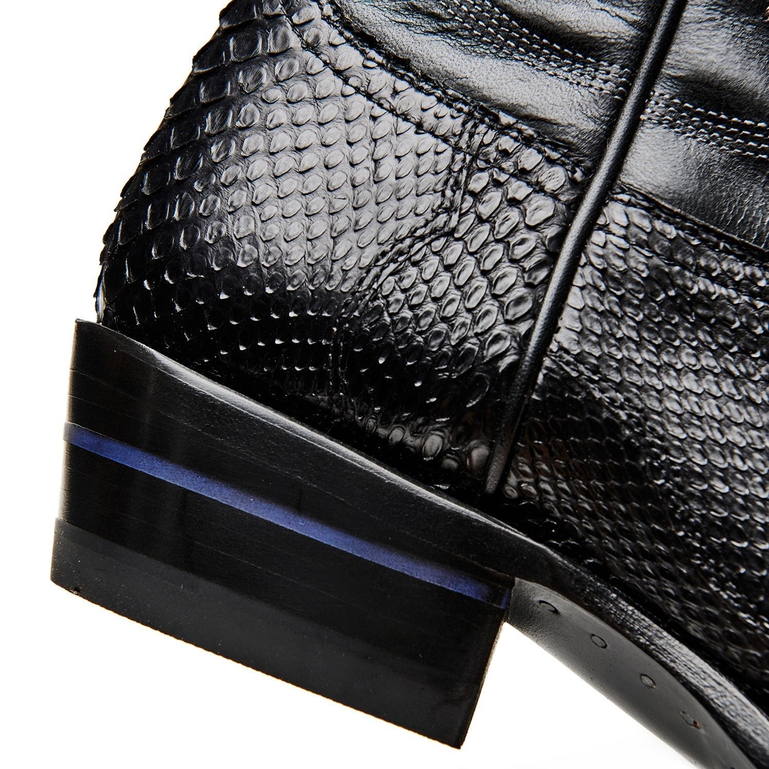 Black cowboy boot side close-up with textured leather and dark blue heel trim