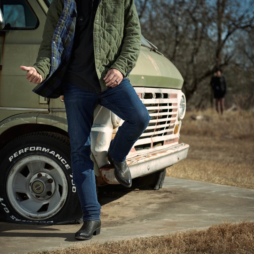 Black cowboy boots worn with jeans, low block heel and textured leather
