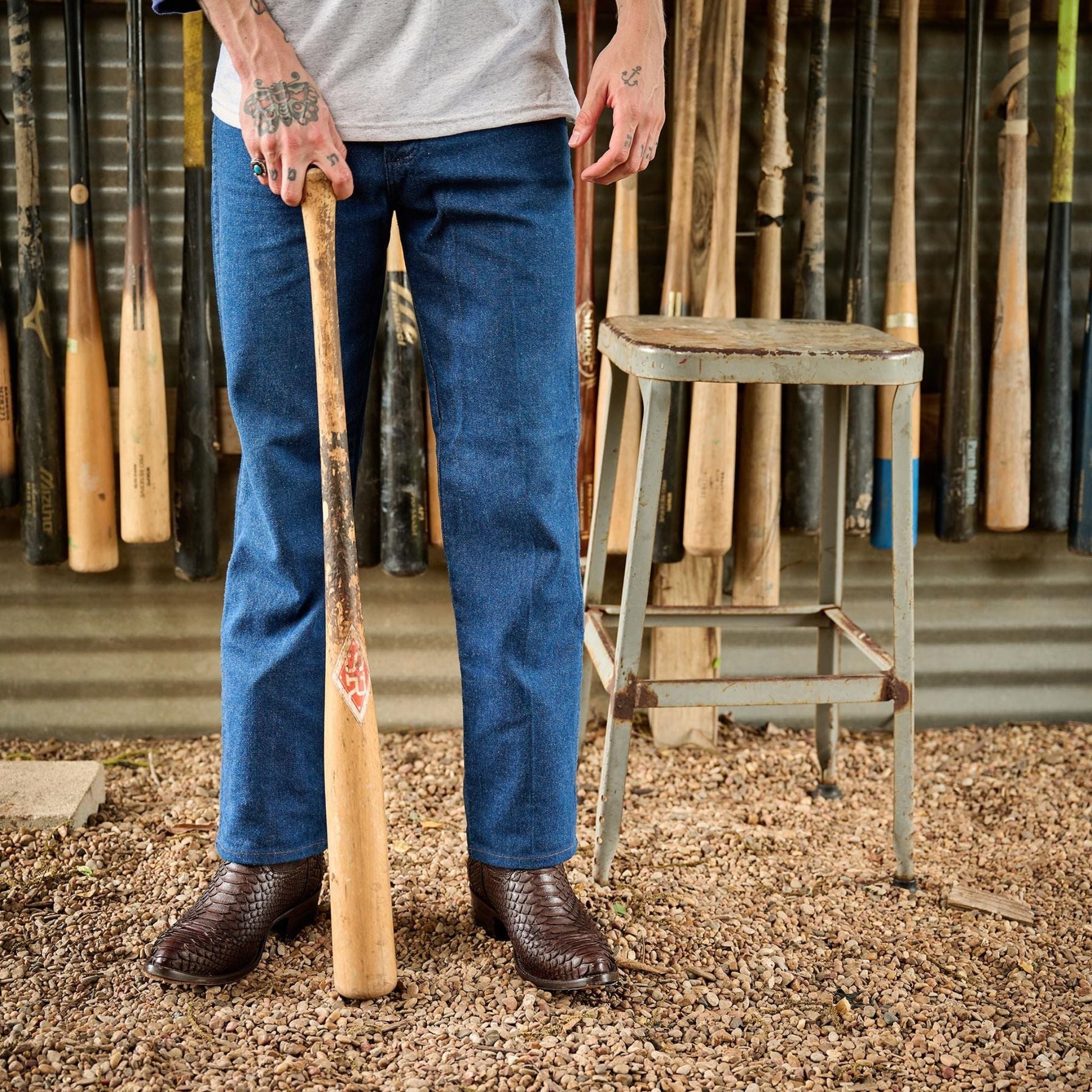 Brown cowboy boots worn with blue jeans, showing rounded heel and textured shaft