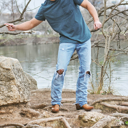 Honey brown cowboy boots on person, square toe and stacked heel visible.