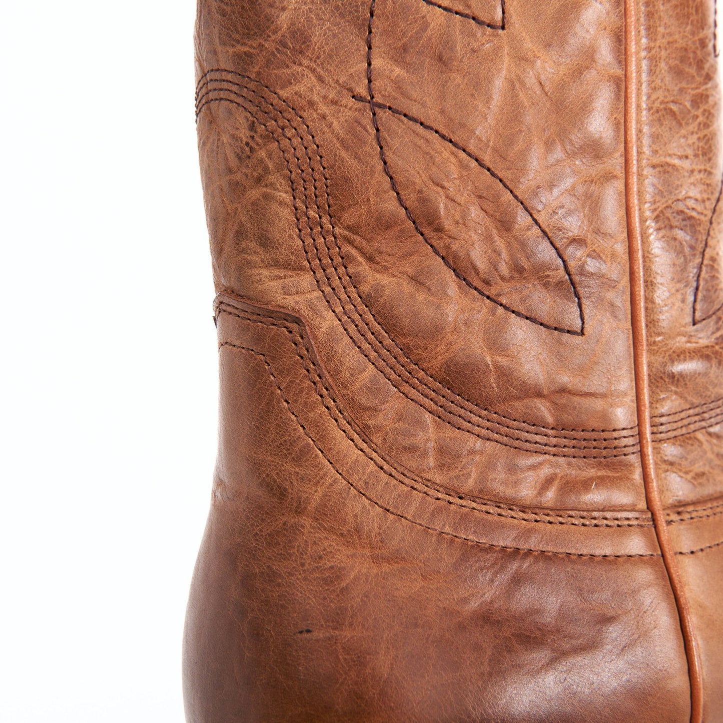 Honey brown leather boot shaft with decorative stitched panels and center seam.