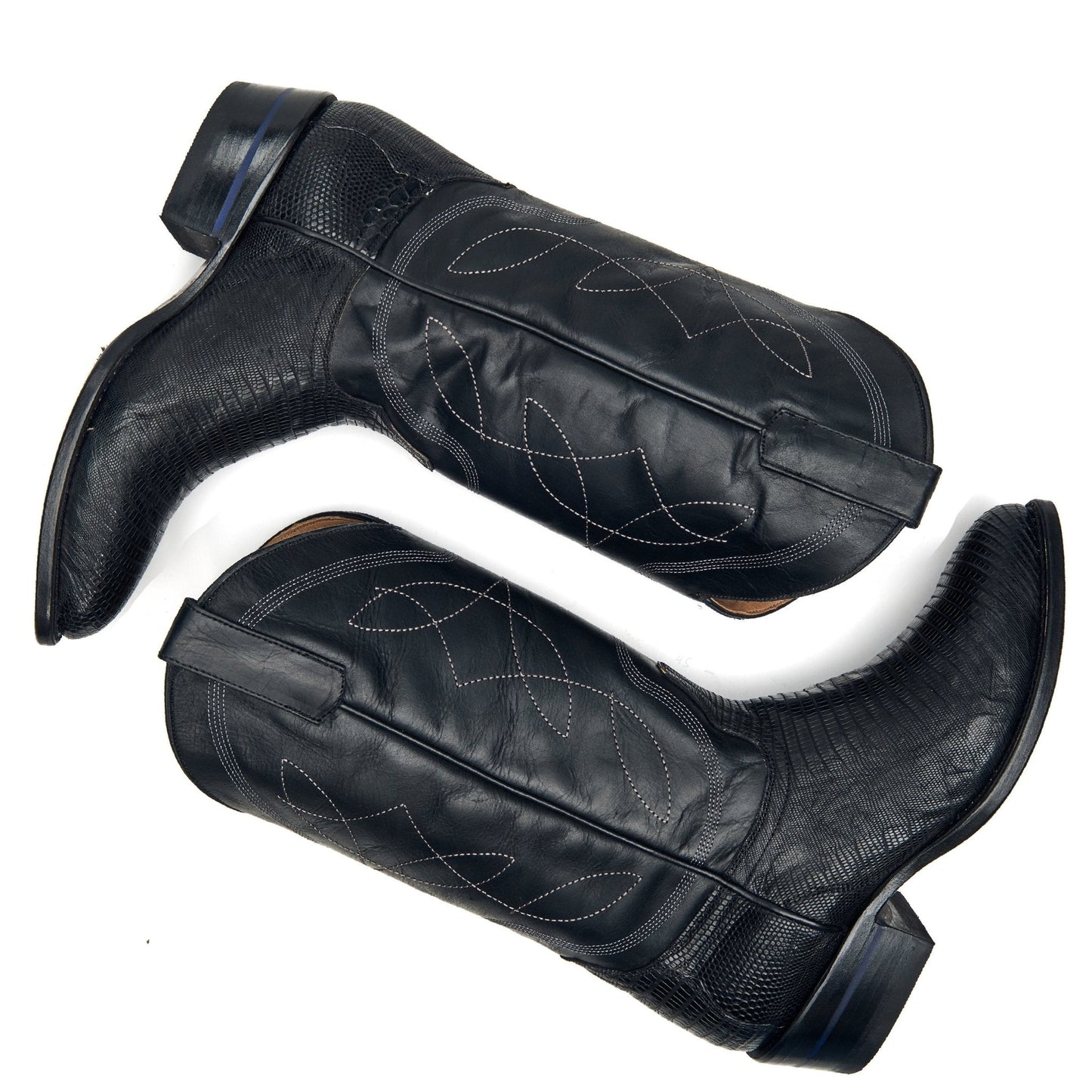 Pair of black cowboy boots with stitched patterns and tall shafts.