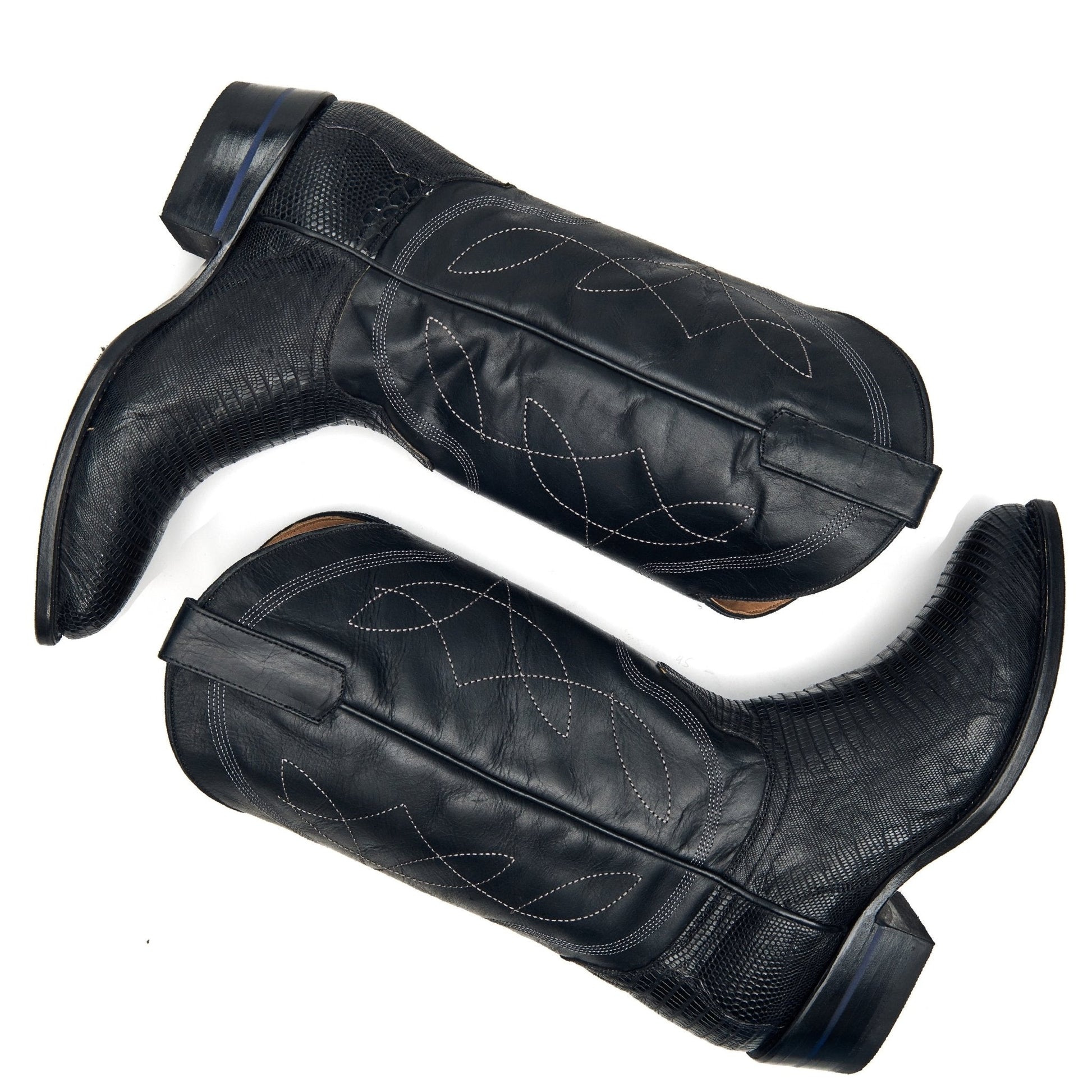 Pair of black cowboy boots with stitched patterns and tall shafts.
