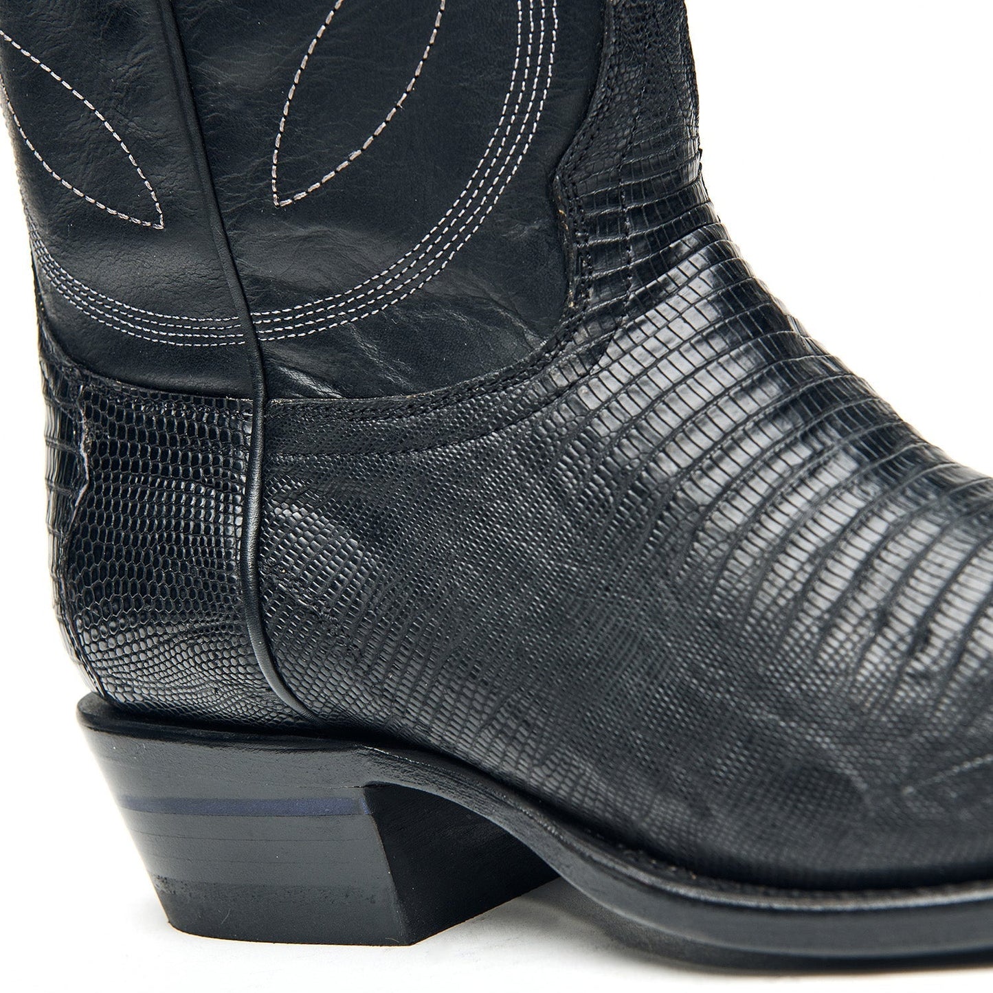 Black cowboy boot heel and side with textured leather and curved stitch accents.