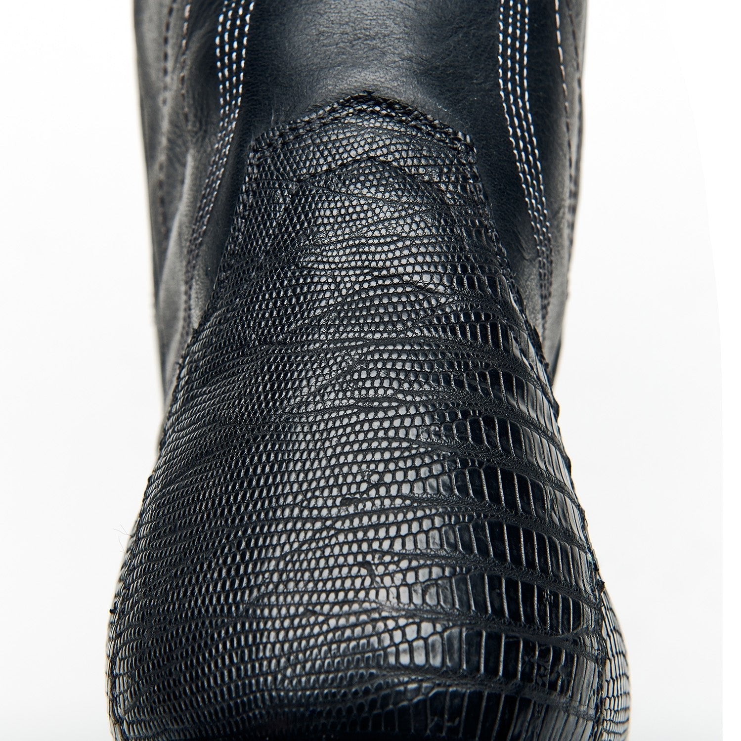 Black cowboy boot upper with fine textured surface and curved stitched overlay.