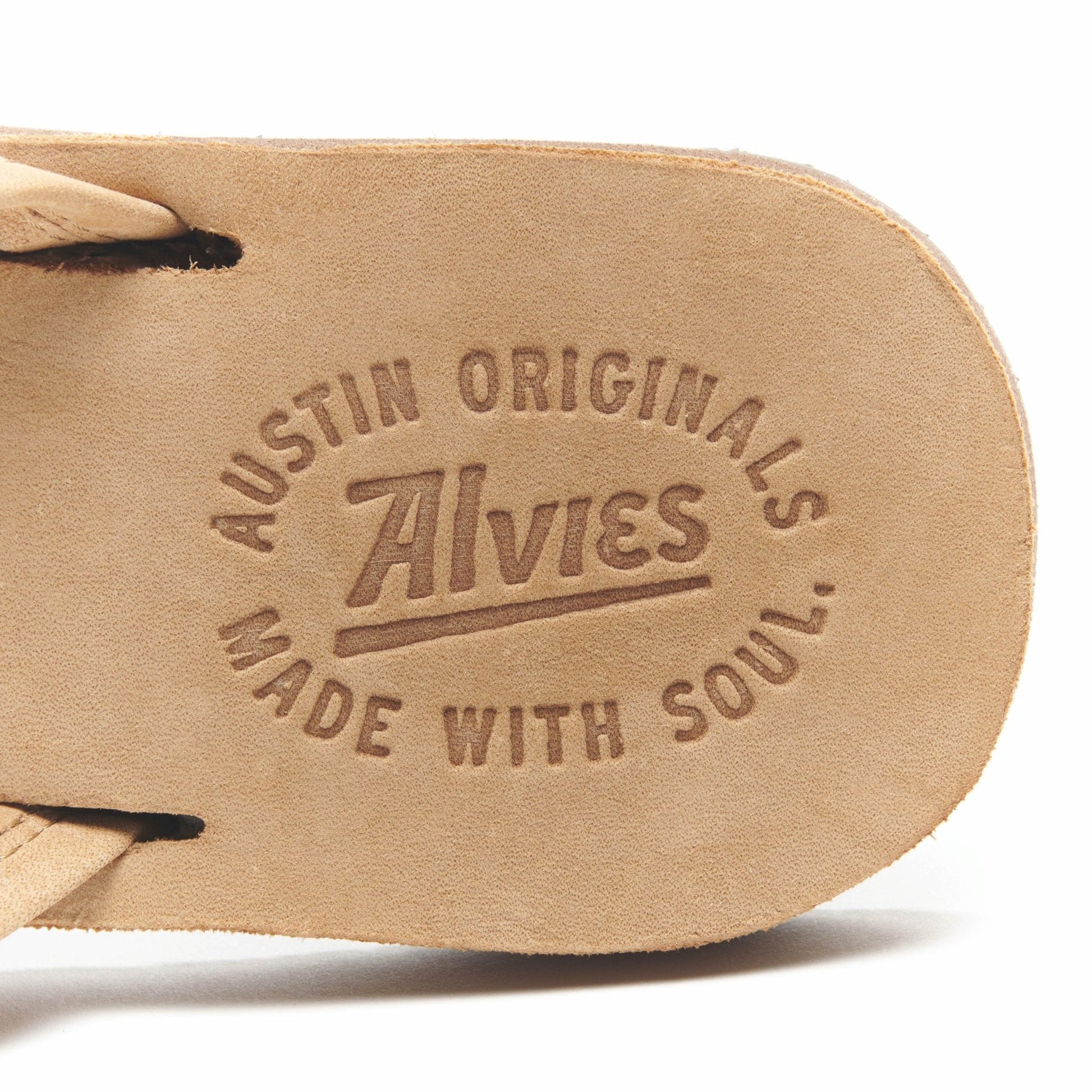 Tan flip-flop footbed with embossed logo text and strap end detail