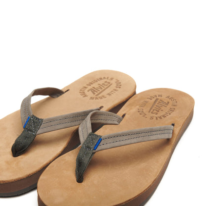 Tan flip-flop sandals with gray straps and blue accents, pair on white background
