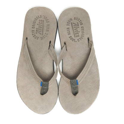 Suede thong sandals showing two footbeds with embossed branding and thin straps