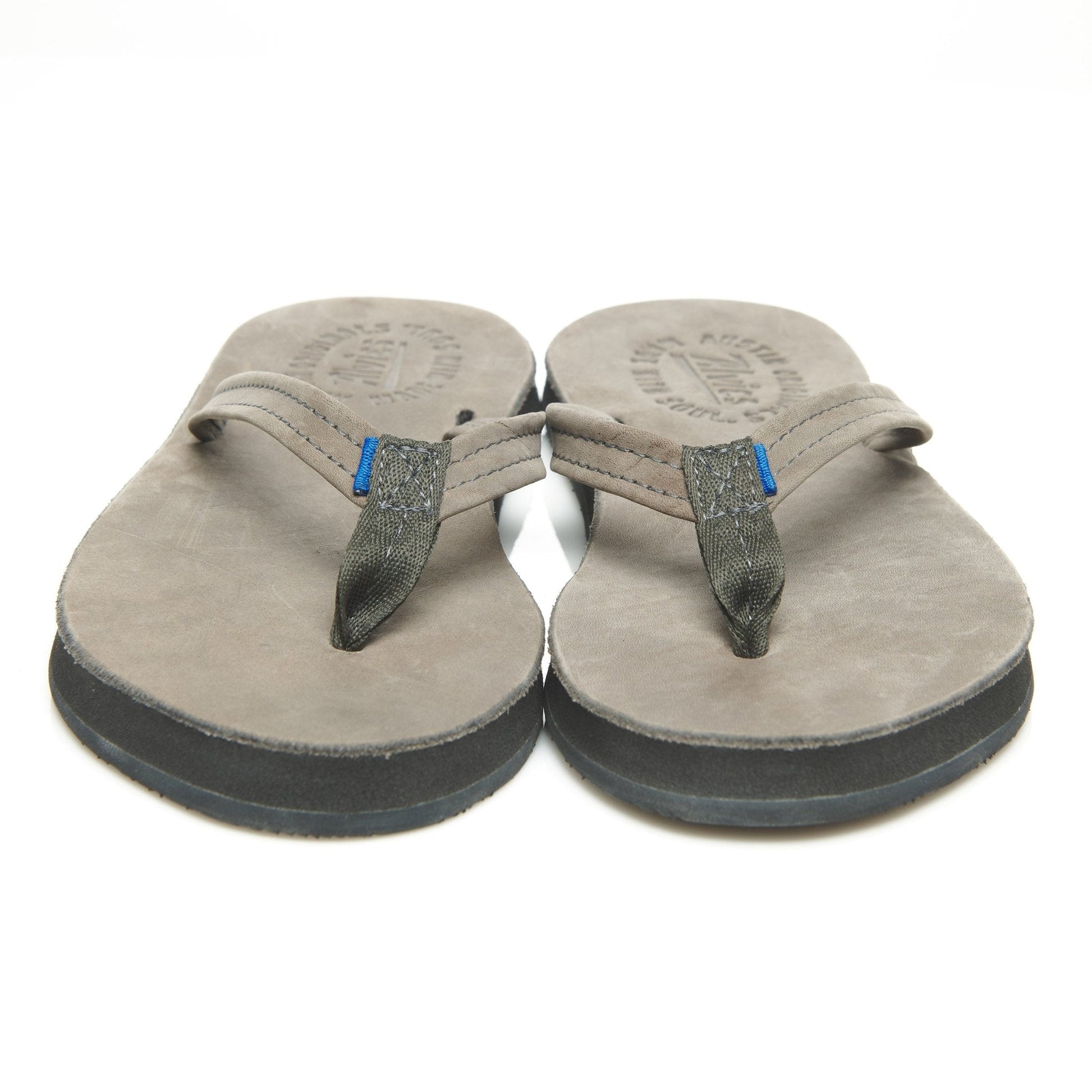 Pair of suede thong sandals, front view with gray rubber soles and blue strap tabs