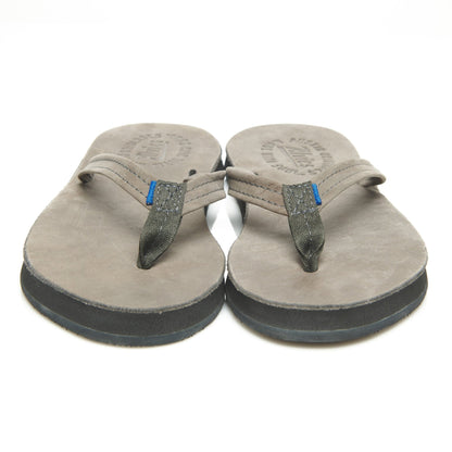 Pair of suede thong sandals, front view with gray rubber soles and blue strap tabs