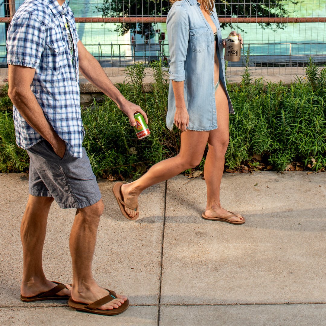 Tan thong sandals on two people walking outdoors on concrete pavement
