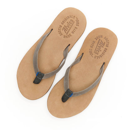Pair of tan flip-flop sandals with gray straps and blue accents, top view