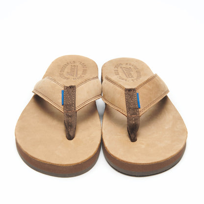 Tan thong flip-flops with dark straps and blue accent stitching, top view