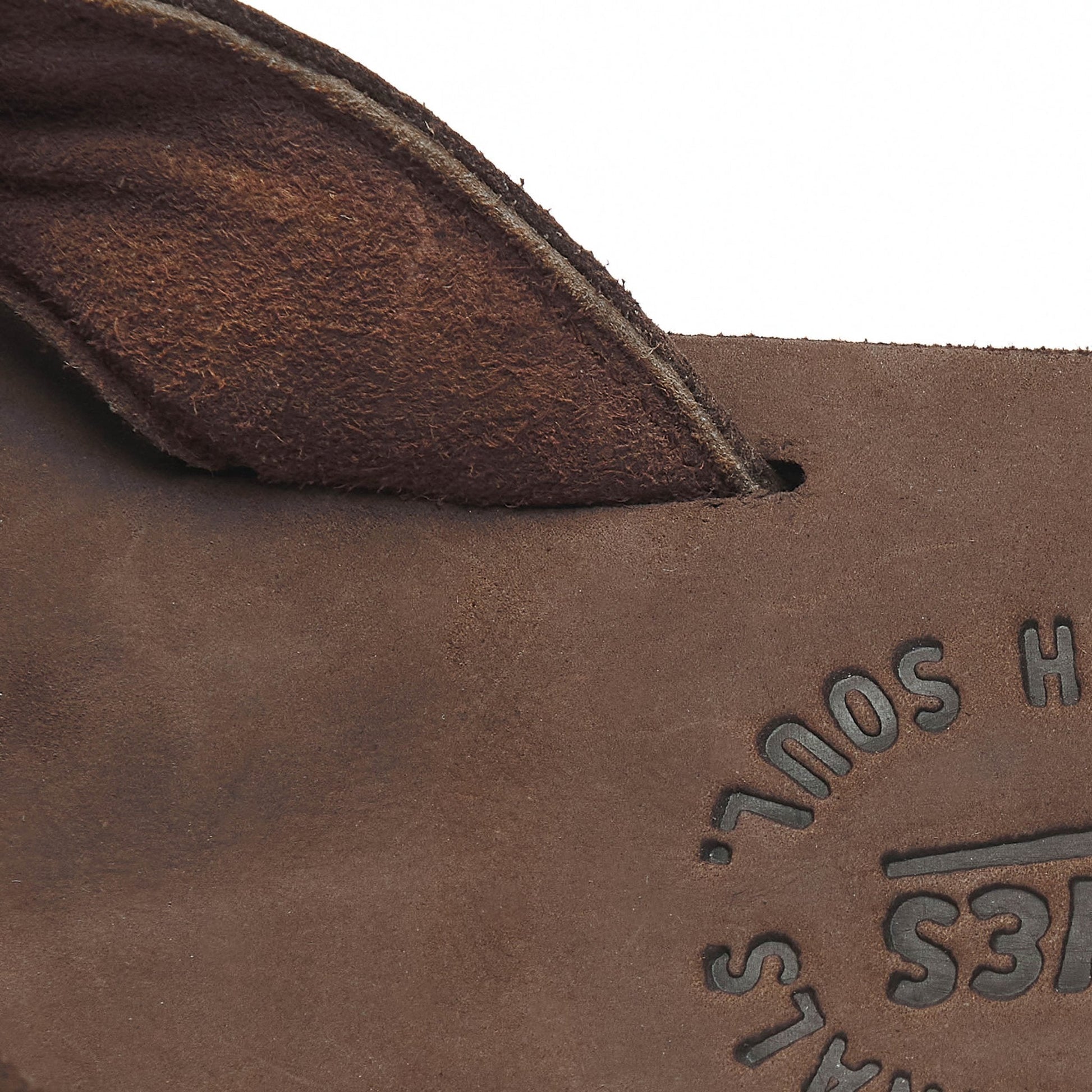 Close-up of brown flip-flop footbed with embossed logo text