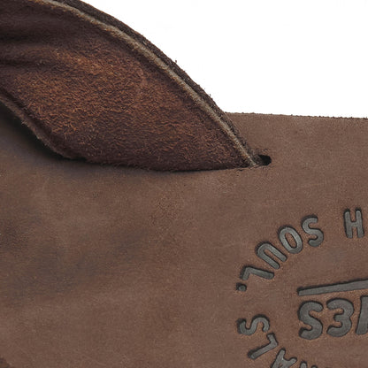Close-up of brown flip-flop footbed with embossed logo text