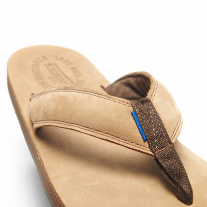 Tan flip-flop sandal with dark brown V-thong strap and blue accent tab