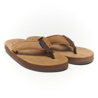 Pair of tan thong flip-flops with dark straps and blue detail stitching